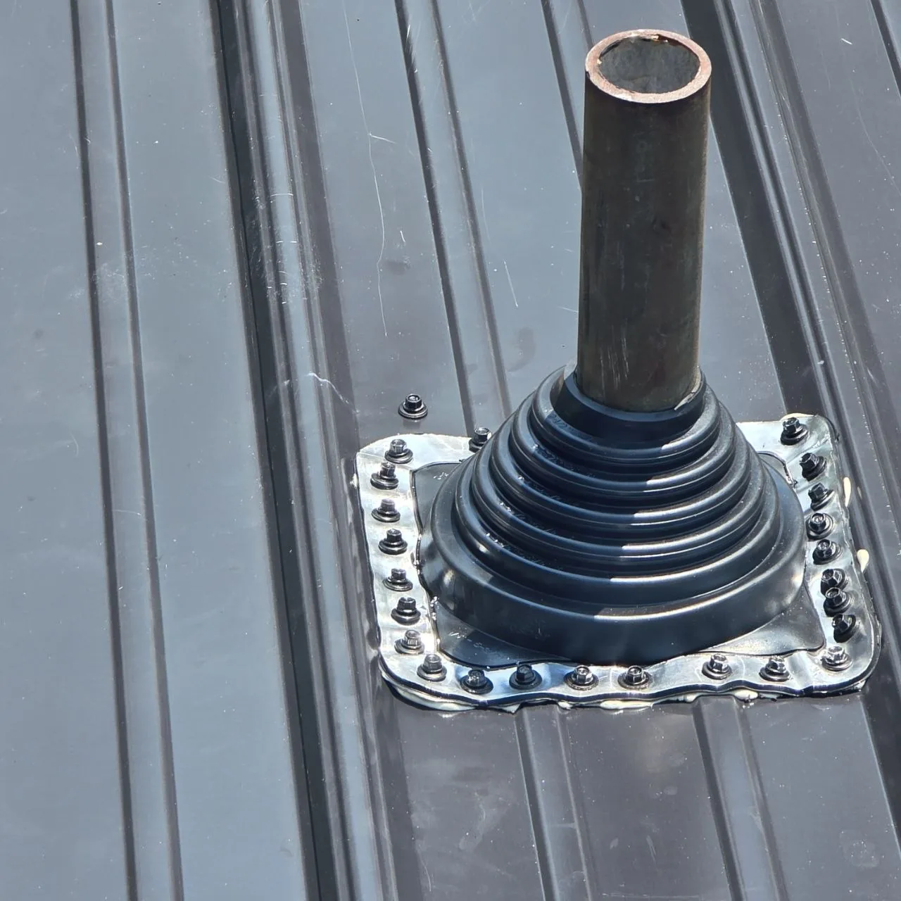 Close view of a flashed pipe penetration on a standing-seam metal roof