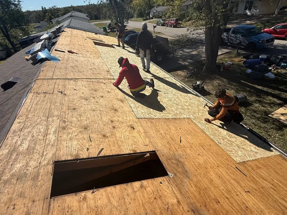Roofing crew preparing roof decking during a replacement project